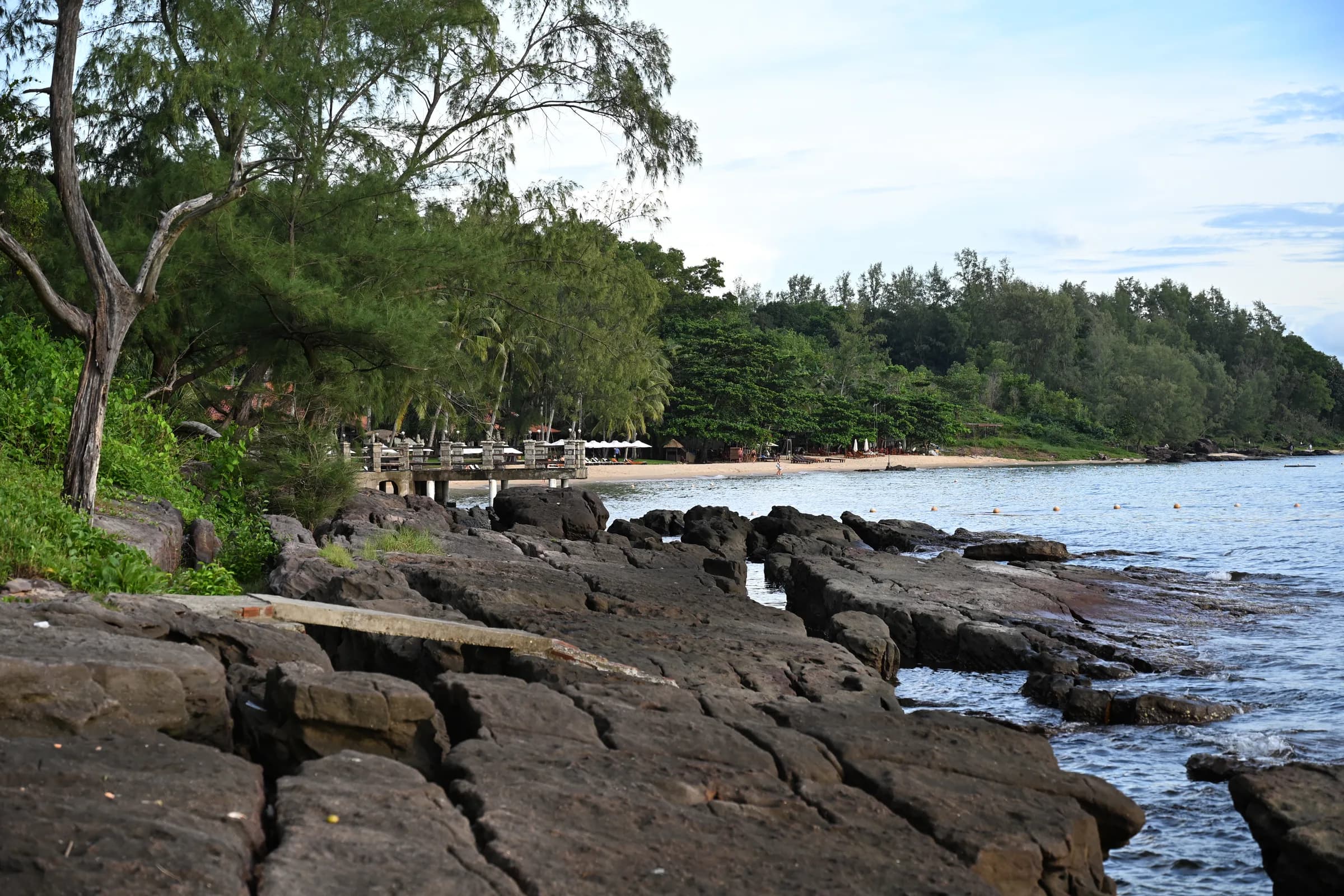 Rocky shoreline and tree-lined beach at Ong Lang
