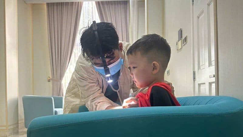 A clinician examines a child during an accommodation visit in Phu Quoc