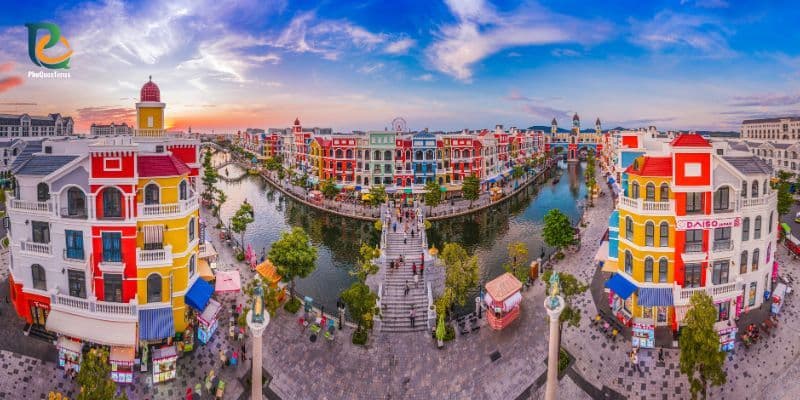 Colorful buildings along the canal at Grand World Phu Quoc with a central pedestrian bridge